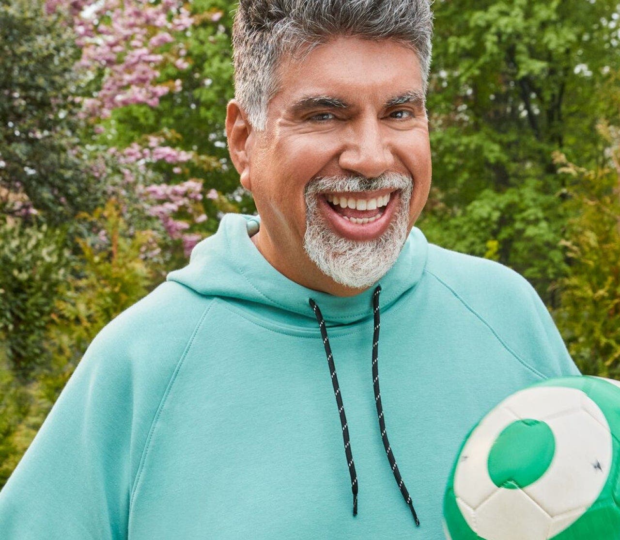G-Plans  WeightLoss member August in a hoody, holding a volleyball and smiling at the viewer.