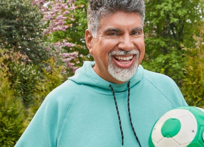G-Plans  WeightLoss member August in a hoody, holding a volleyball and smiling at the viewer.